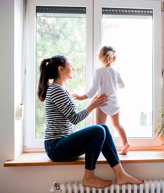 Femme avec son enfant à une fenêtre
